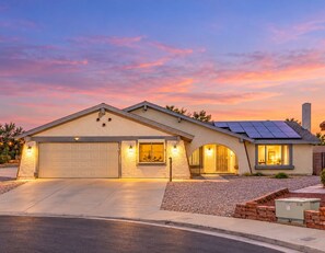 A two-story house with a garage, solar panels, and a driveway.