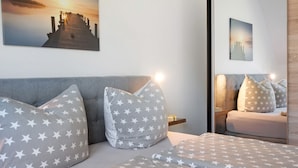 A bedroom with a bed, pillows, and a nightstand.