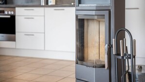 A modern kitchen with white cabinetry, a built-in oven, and a stainless steel range hood. - Sustainable Holiday Apartment "Lichtblick" with Private Terrace, Garden, Wi-Fi & EV Charger (Grömitz)