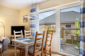 A dining area with a table, chairs, and a TV.