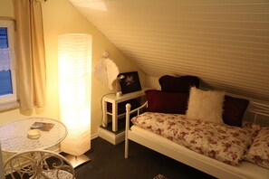 A small, cozy room with a single bed, a table with a bowl, and a lamp. - Apartment 'Ferienwohnung Mandelblüte' with Mountain View and Wi-Fi (Schotten)
