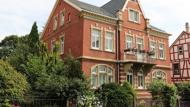 A large, red brick building with multiple windows and a balcony with flowers. - Apartment 'Ferienwohnung Mandelblüte' with Mountain View and Wi-Fi (Schotten)