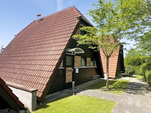 A modern building with a sloped roof, a brick exterior, and a small tree in the yard. - Holiday Home Exquisit – One of the Finest Houses in the Holiday Park! (Immenstaad)