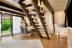 Un interior moderno con una escalera de madera, un comedor y una cocina.
