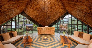 A spacious room with a high ceiling, large windows, and a central wooden desk. - Justa Lazy Haven Corbett, Uttarakhand (Ramnagar)