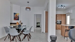 A modern kitchen with wooden cabinets and a built-in oven. - Phaedrus Living: Luxury Residence Faneromeni (Larnaca)