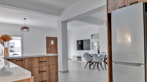 A modern kitchen with a wooden island, white cabinetry, and a built-in refrigerator. - Phaedrus Living: Luxury Residence Faneromeni (Larnaca)