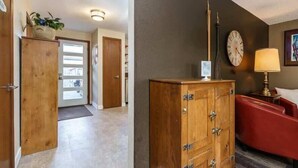 Un hall d’hôtel avec un meuble en bois, un canapé rouge, une horloge et une lampe.