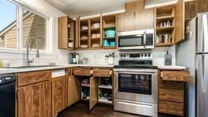 Eine Küche mit Holzausstattung, einem Backofen und einer Mikrowelle.