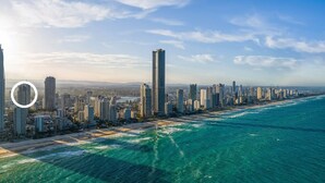 An aerial view of a coastal city with high-rise buildings along the beachfront. - `Family Beach Getaway` by Inn Paradise (Surfers Paradise)