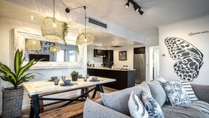 A modern kitchen with a central island, pendant lighting, and a large butterfly mural on the wall. - `Boutique Sky Villa` by Inn Paradise (Surfers Paradise)
