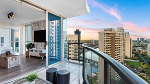 A modern apartment with a balcony, large windows, and a city view. - `Boutique Sky Villa` by Inn Paradise (Surfers Paradise)