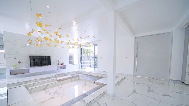 A spacious interior with a marble floor, a large seating area, and a television. - EL AMO LAKEVIEW VILLA (Entebbe)