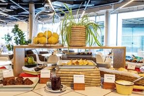 A buffet with various food items and labels, including a plant, lemons, and different types of baked goods. - One Thibault Residence By Itc Hospitality (Cape Town)