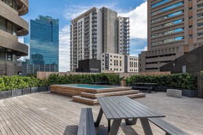 A rooftop terrace with a pool, wooden deck, and seating areas. - One Thibault Residence By Itc Hospitality (Cape Town)