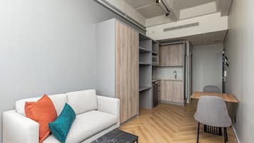 Een moderne woonkamer met een bank, een salontafel en een eethoek met een stoel en tafel.