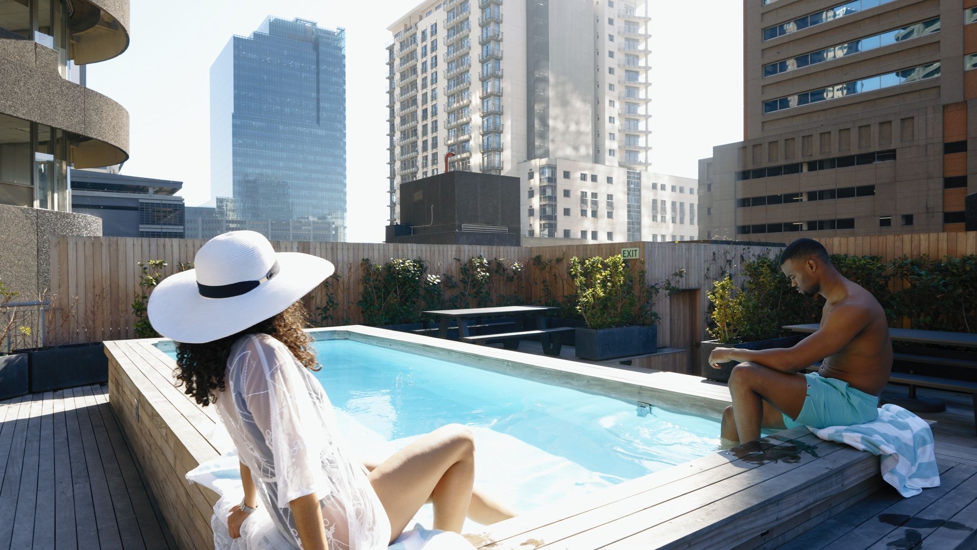 Un espace piscine aménagé sur le toit, offrant une vue sur les immeubles environnants.
