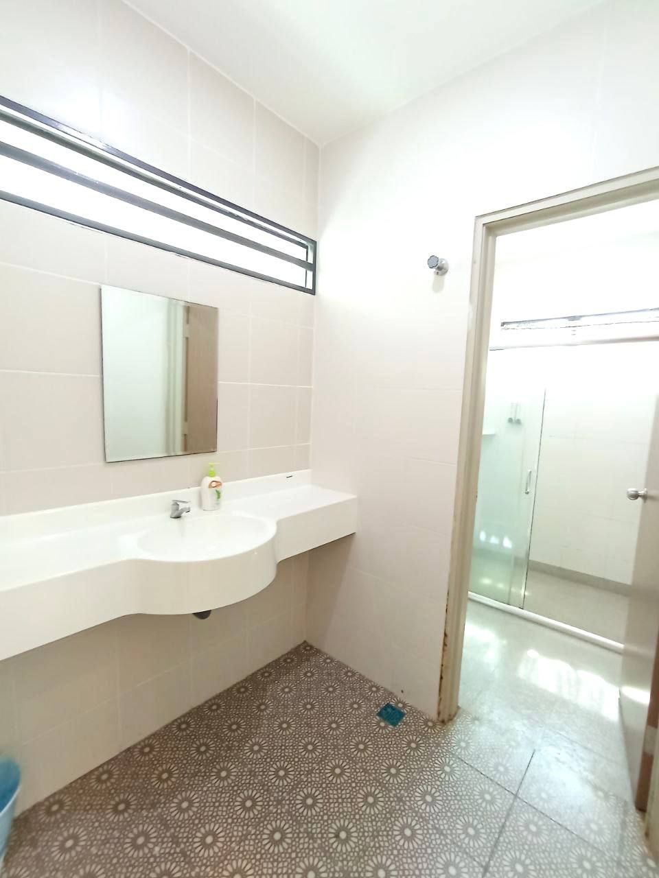 A bathroom with a white sink, mirror, and patterned floor tiles.