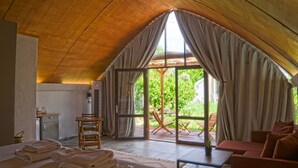 Une pièce chaleureuse, baignée de lumière naturelle, avec un plafond en pente, un coin repas et une vue sur l’extérieur.