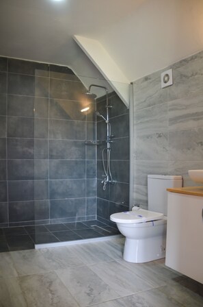 Ein modernes Badezimmer mit Dusche, Toilette und Waschbecken.