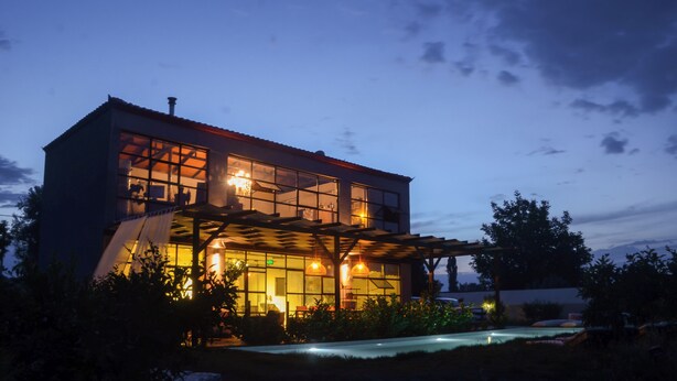 Un bâtiment moderne à deux étages, doté de grandes fenêtres et d’un espace extérieur abrité.