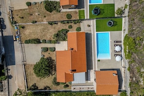 An aerial view of a property with multiple buildings, a swimming pool, and landscaped areas. - Holiday Home Asteria (Labin)