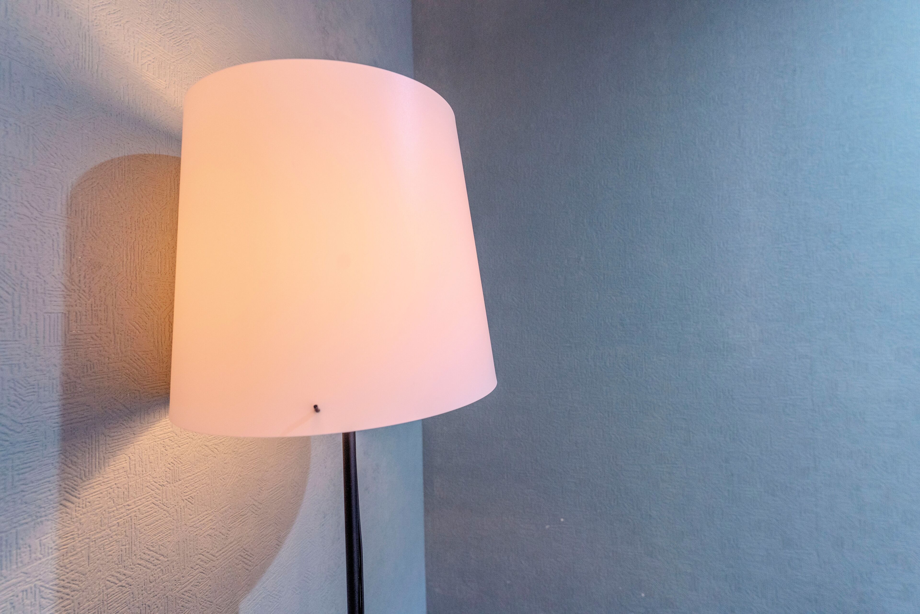 A wall-mounted lamp with a cylindrical shade.