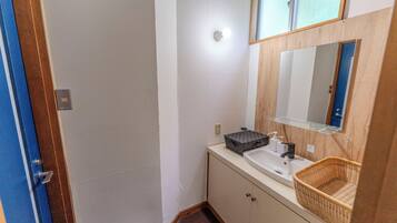 A bathroom with a sink, mirror, and a wicker basket.