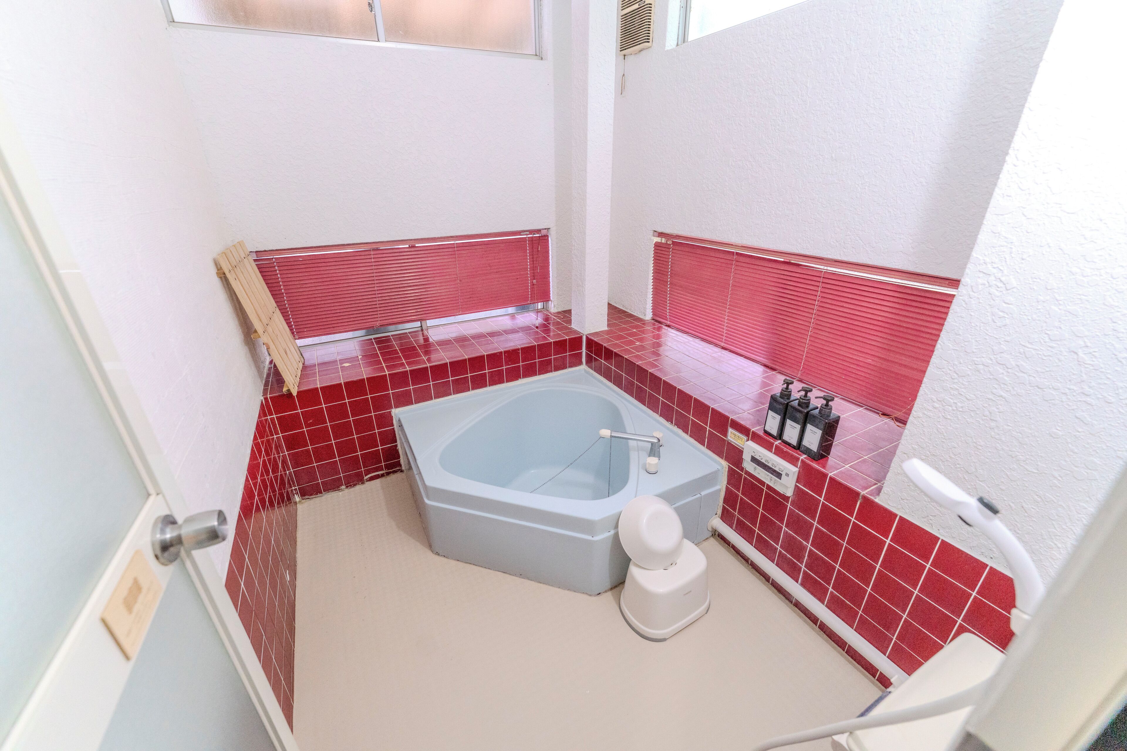 A bathroom with a bathtub, a toilet, and a shower area.