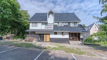 A two-story house with a gabled roof, a front porch, and a garage.