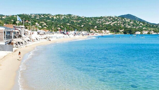 A beach with clear blue water, a sandy shore, and buildings in the background. - Family House in Provence with Pool and Garden (Draguignan)