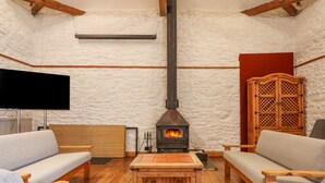 Una sala de estar acogedora con chimenea, muebles de madera y un televisor de pantalla plana.