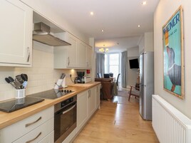 A modern kitchen with a wooden countertop, stainless steel appliances, and a dining area with a view.