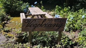 Un banco de madera con un letrero que dice "Vogelking" en un jardín.