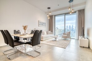 Un salon moderne avec un coin repas, de grandes fenêtres et une vue sur la ville.