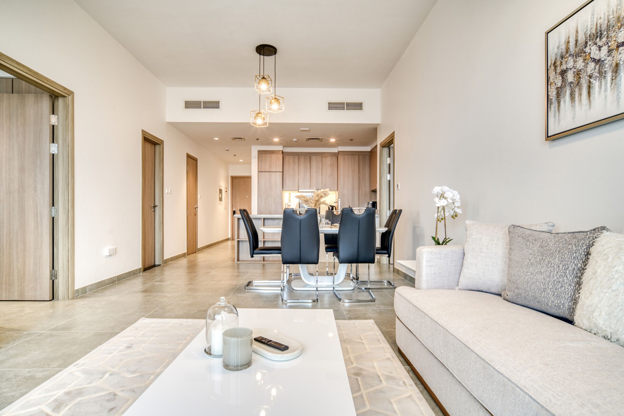 Un salon moderne comprenant un canapé, une table basse et un coin repas avec des chaises et une table.