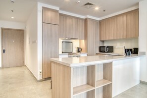 Une cuisine moderne avec des meubles en bois, un îlot central et des appareils électroménagers intégrés.