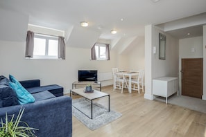 Relax in a cozy living space with a comfortable seating area, flat-screen TV, and dining table.