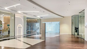 Un intérieur moderne avec une balustrade en verre, un plancher en bois et une enseigne indiquant « MDI HOME ».