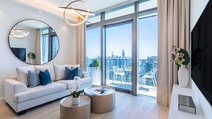 Ein modernes Wohnzimmer mit einer Couch, einem Couchtisch und einem großen Fenster mit Blick auf die Stadt.