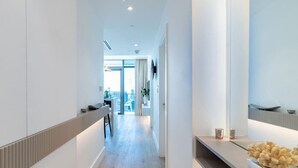 Ein moderner Hotelkorridor mit Holzboden, einer Rezeption und einem großen Spiegel an der Wand.