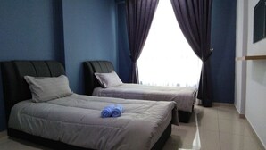 Habitación de hotel con dos camas, un ventanal grande con cortinas oscuras, una lámpara de techo y un televisor de pantalla plana montado en la pared.