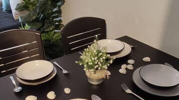 A dining table set with plates, cutlery, and a centerpiece.