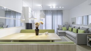 A modern living room with a dining area, a sofa set, and a large mirror. - Italianway Comfort - Compagnoni 12 - Suite Mirabel (Milan)