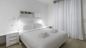A modern hotel room with a neatly made bed, a bedside table, and a built-in wardrobe. - Italianway Comfort - Compagnoni 12 - Suite Mirabel (Milan)