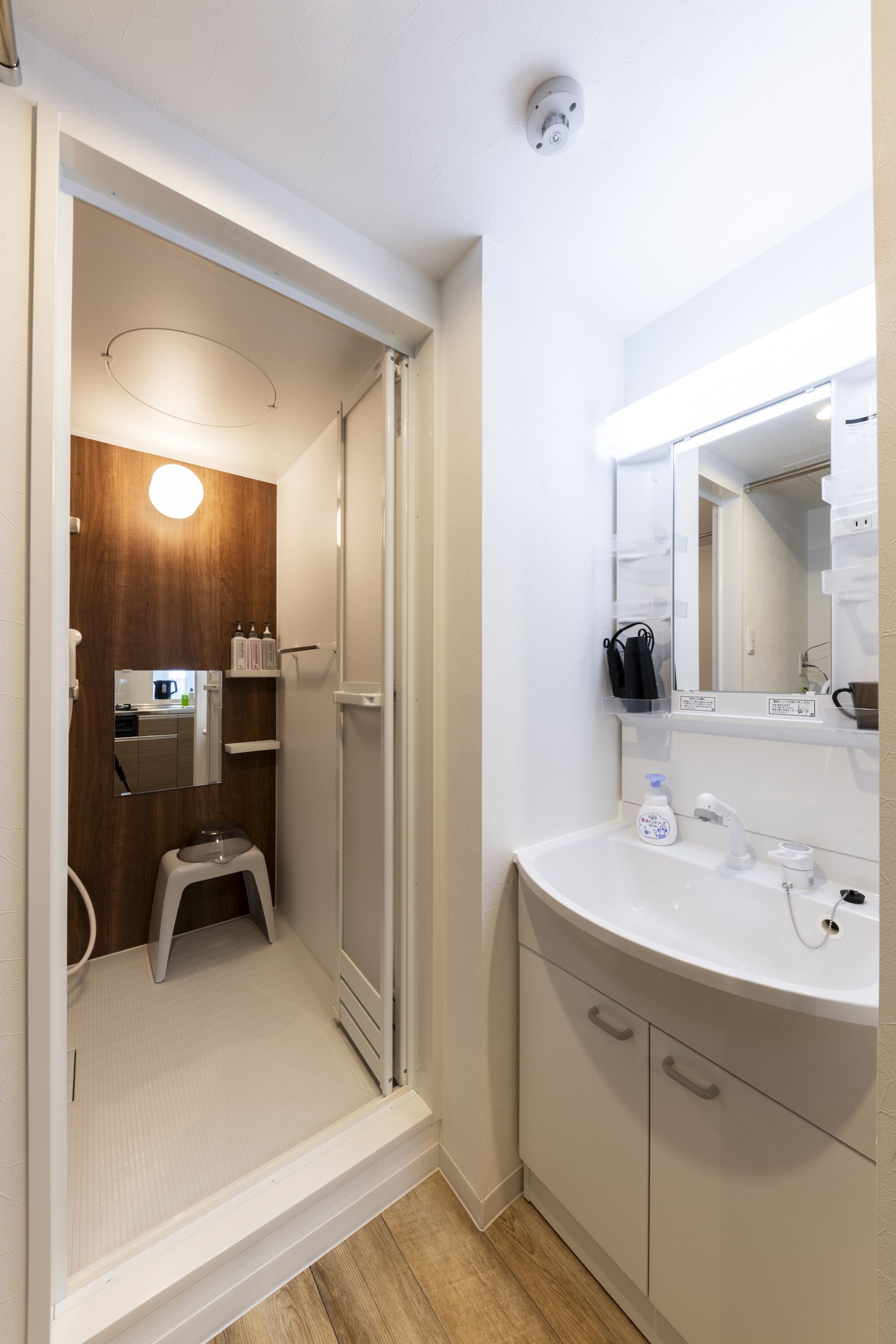 A modern bathroom with a shower, toilet, and sink.