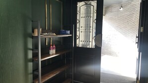 A room with a black door, a shelf with items, and a brick wall. - Dayin International Youth Hotel (Shanghai Xinhua Road Jiaotong University Branch) (Shanghai)