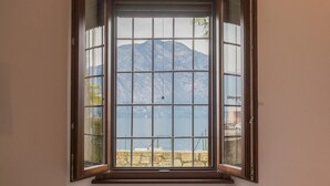 A window with a view of a mountain and a body of water.