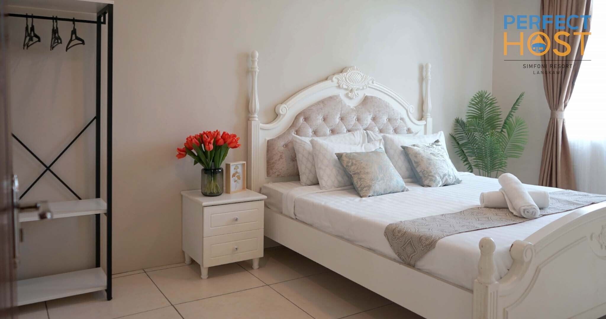 Une chambre à coucher bien rangée, avec un lit, une table de chevet et un petit meuble.