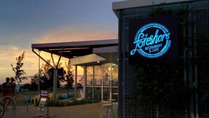 A restaurant with a neon sign reading "The Forest" and a covered outdoor seating area. - Nightcliff Foreshore Seaview Pool Workspace (Rapid Creek)
